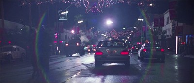 cars driving down a city street at night