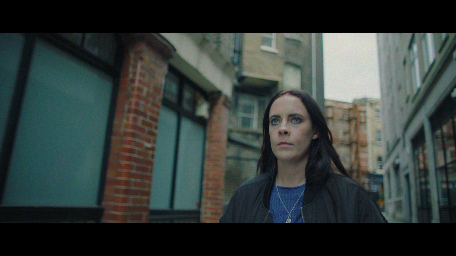 a woman standing in front of a brick building