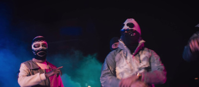 two people wearing gas masks on a stage