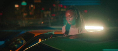 a woman standing next to a car at night