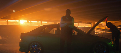 a man standing next to a car in a parking lot