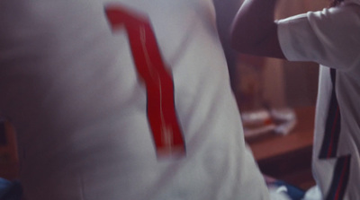 a man holding a baseball bat next to a man in a white shirt