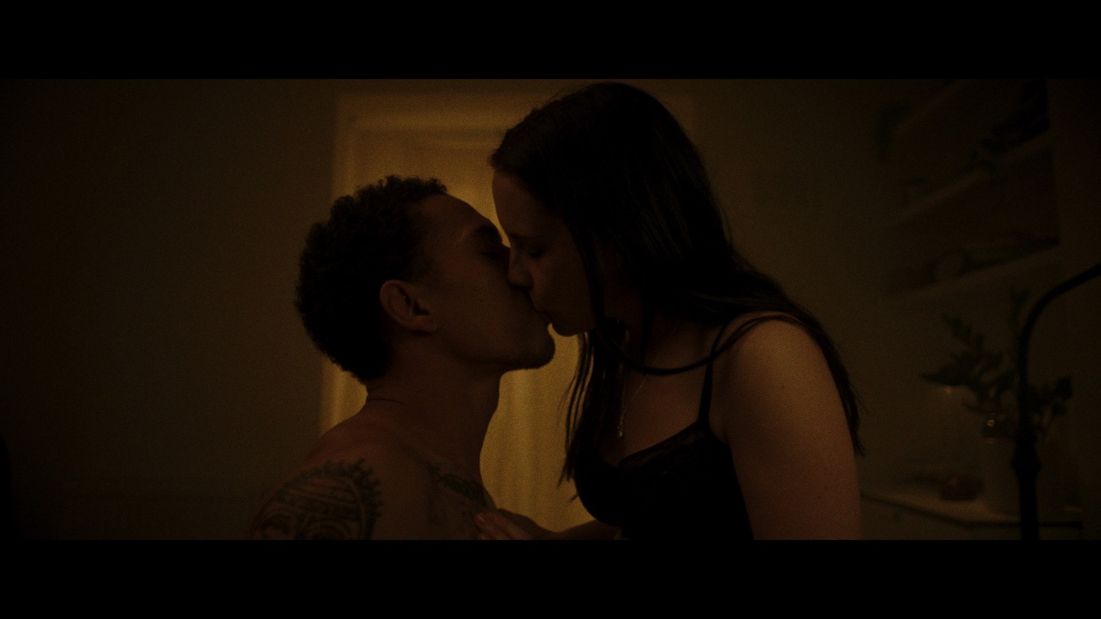 a man and a woman kissing in a dark room