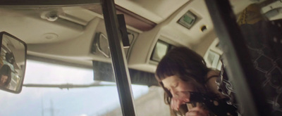 a woman sitting in a bus talking on a cell phone