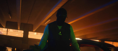 a man standing in a parking garage next to a car