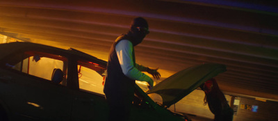 a man standing next to a car holding a surfboard