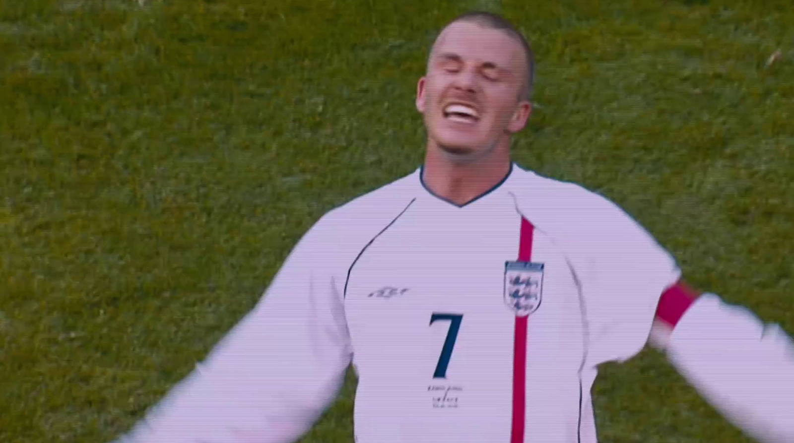 a man in a soccer uniform standing on a field