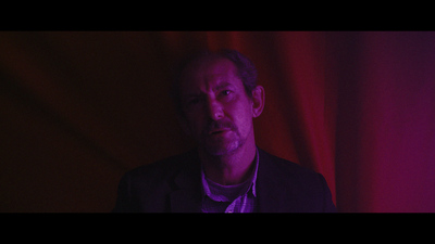 a man standing in front of a red curtain