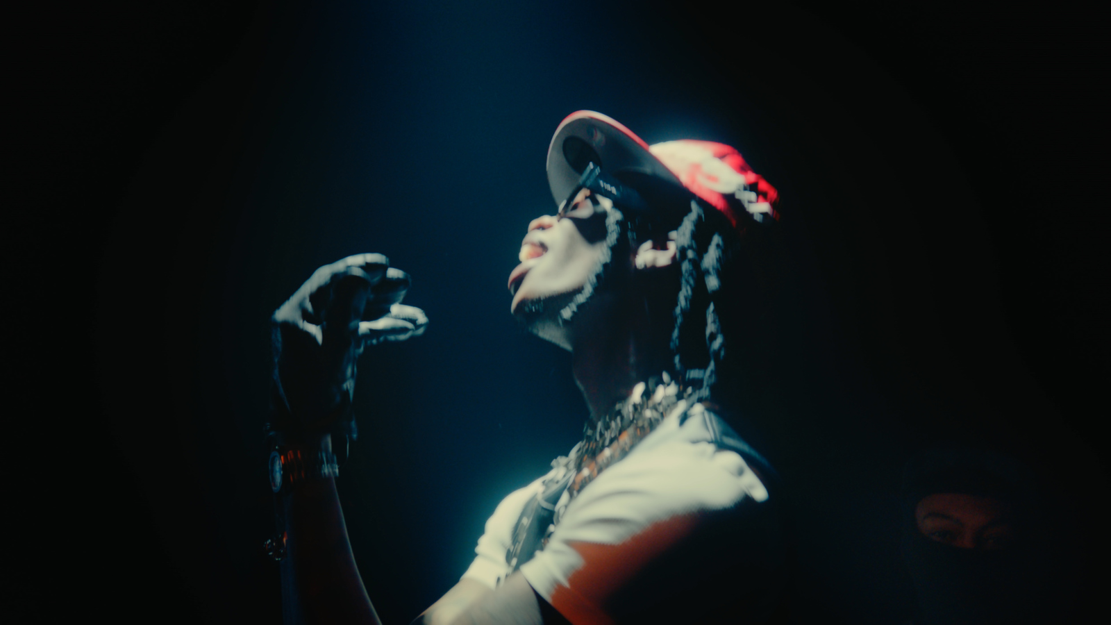 a man with dreadlocks and a hat on holding a microphone