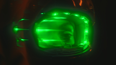 a close up of a green light in a dark room