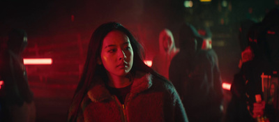 a woman standing in a dark room with red lights