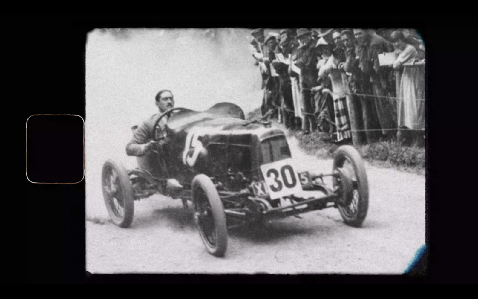 an old photo of a man driving a race car