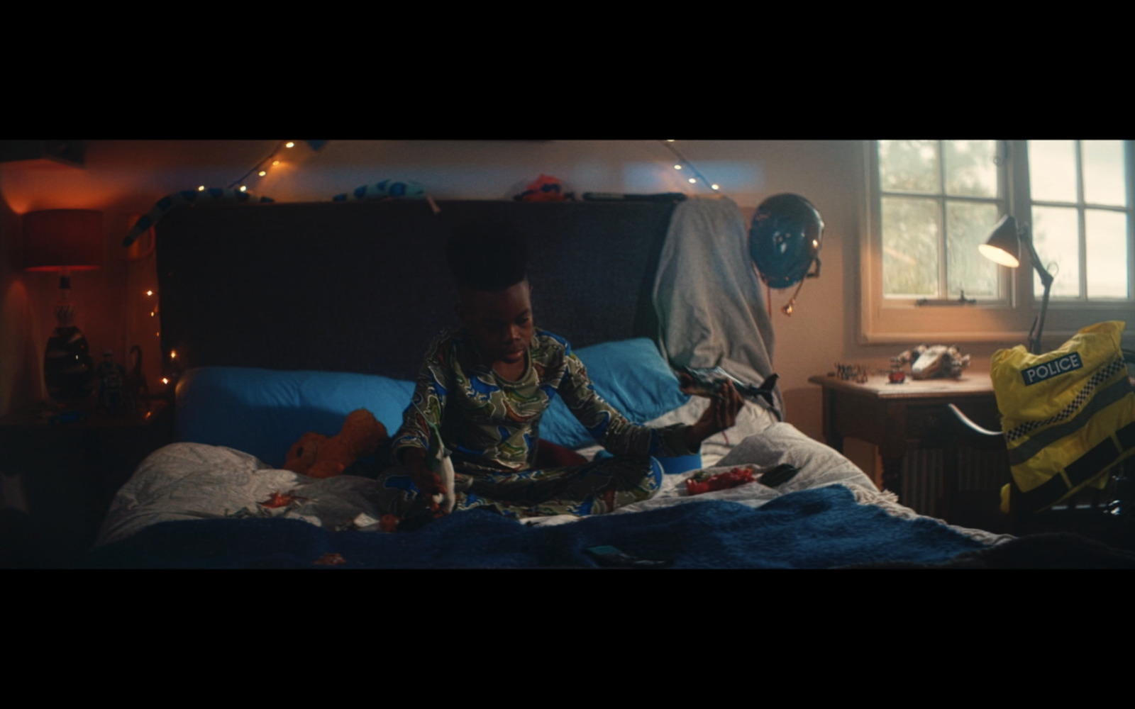 a child sitting on a bed with a stuffed animal