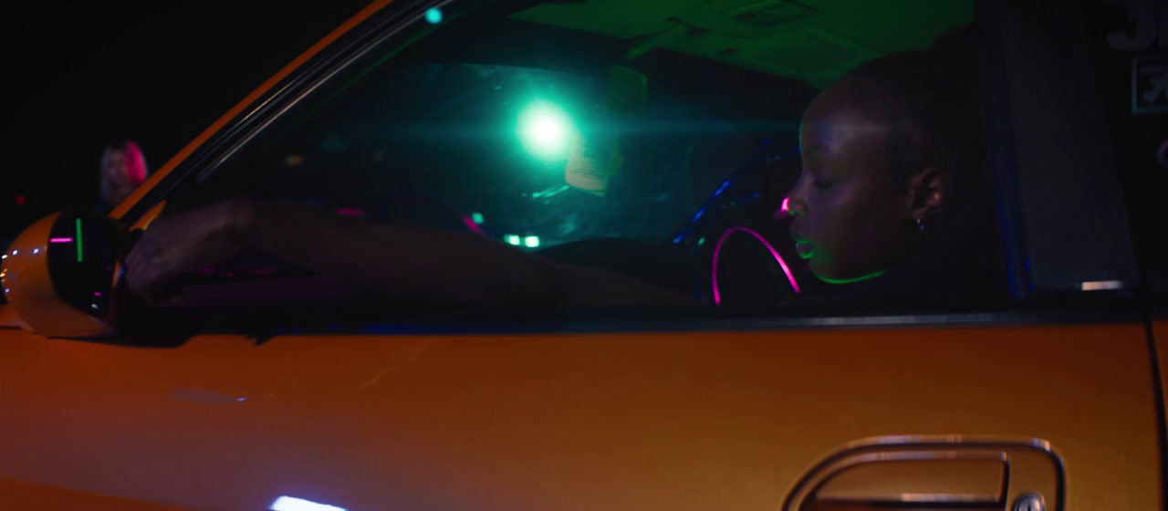 a man driving a car at night with a green light