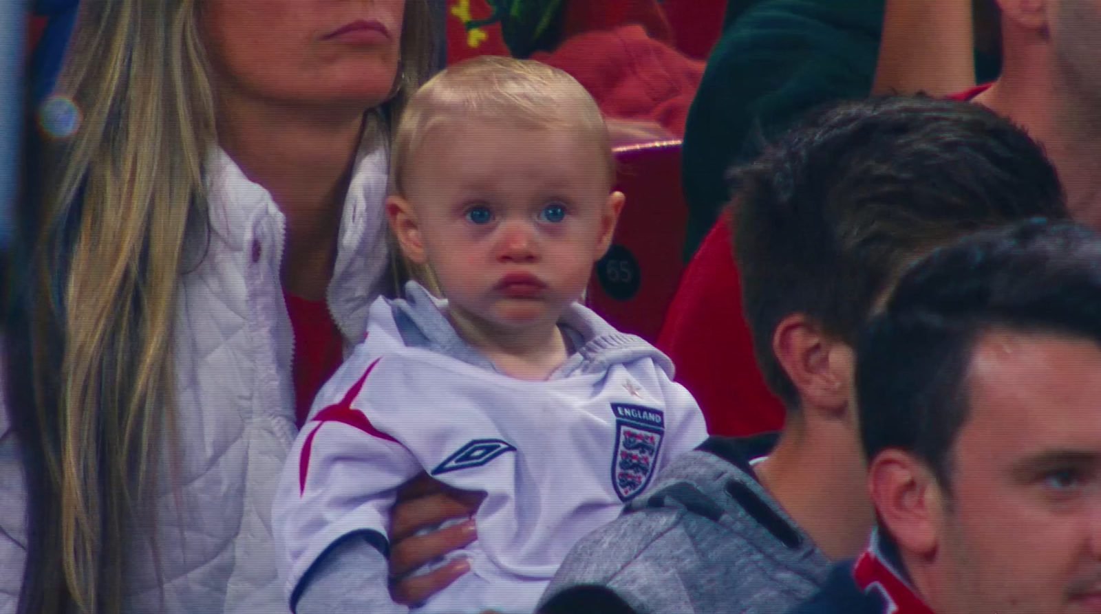 a baby sitting in a crowd of people