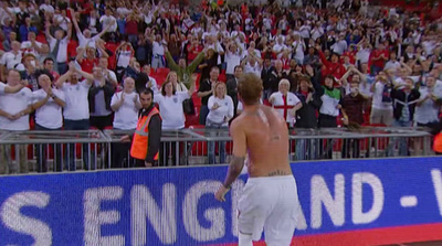 a shirtless male tennis player walking on a tennis court