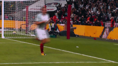 a man kicking a soccer ball across a field