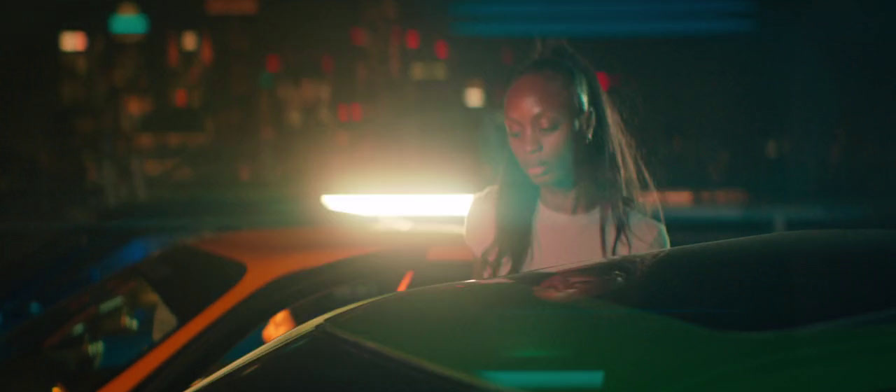 a woman standing next to a car in the dark