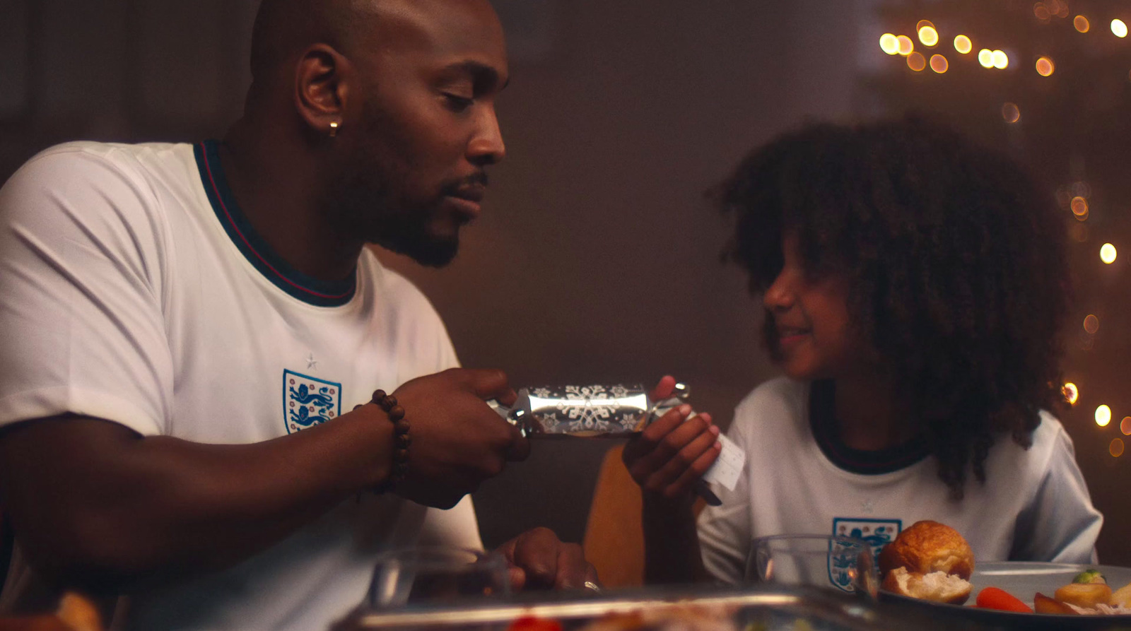 a man and a woman sitting at a table with food