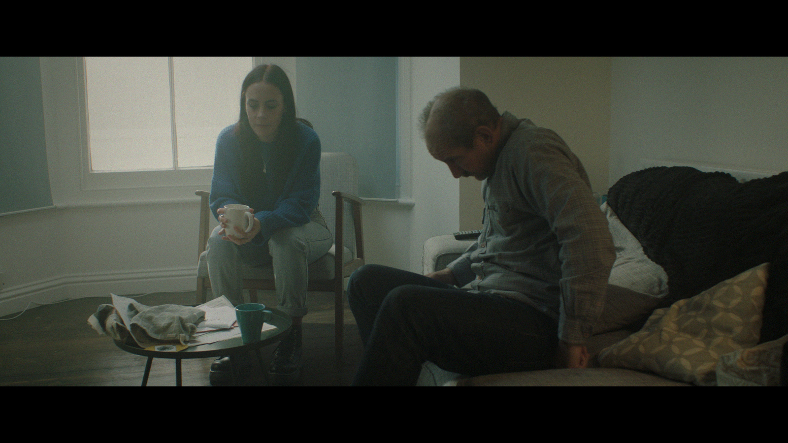 a man and a woman sitting on a couch in a living room