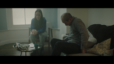 a man and a woman sitting on a couch in a living room