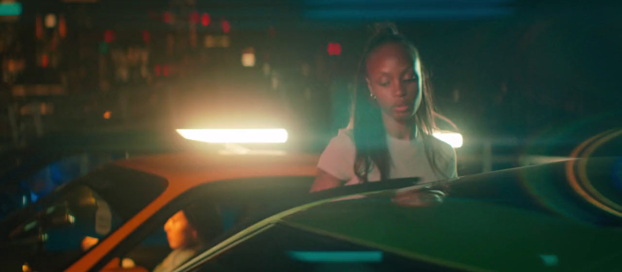 a woman standing in front of a car at night