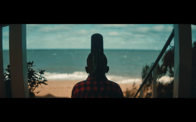 a woman looking out a window at the ocean