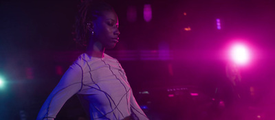 a woman standing in front of a purple light