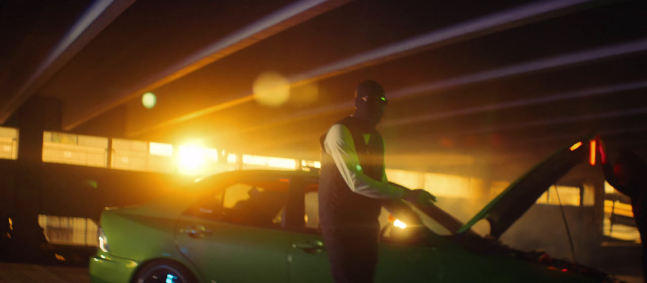 a man standing next to a green car