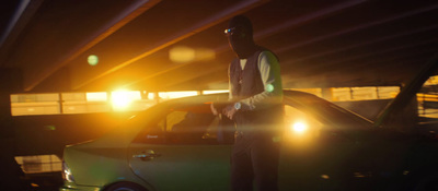 a man standing next to a green car