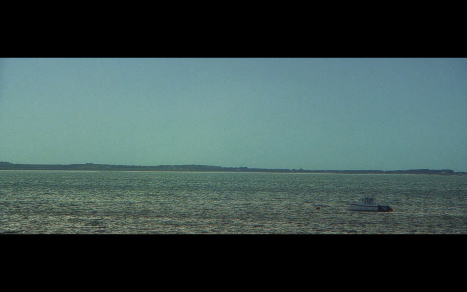 a small boat floating on top of a large body of water