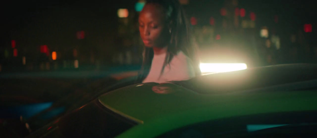 a woman sitting on top of a green car