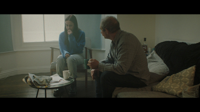 a man and a woman sitting on a couch in a living room