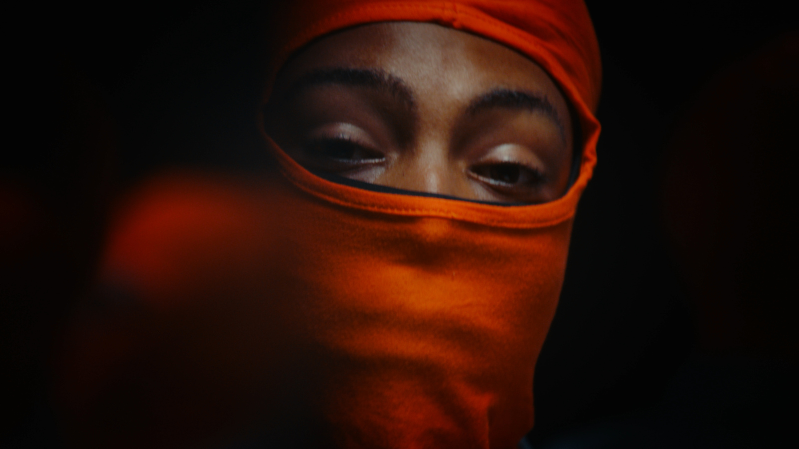 a woman wearing a red head covering over her eyes