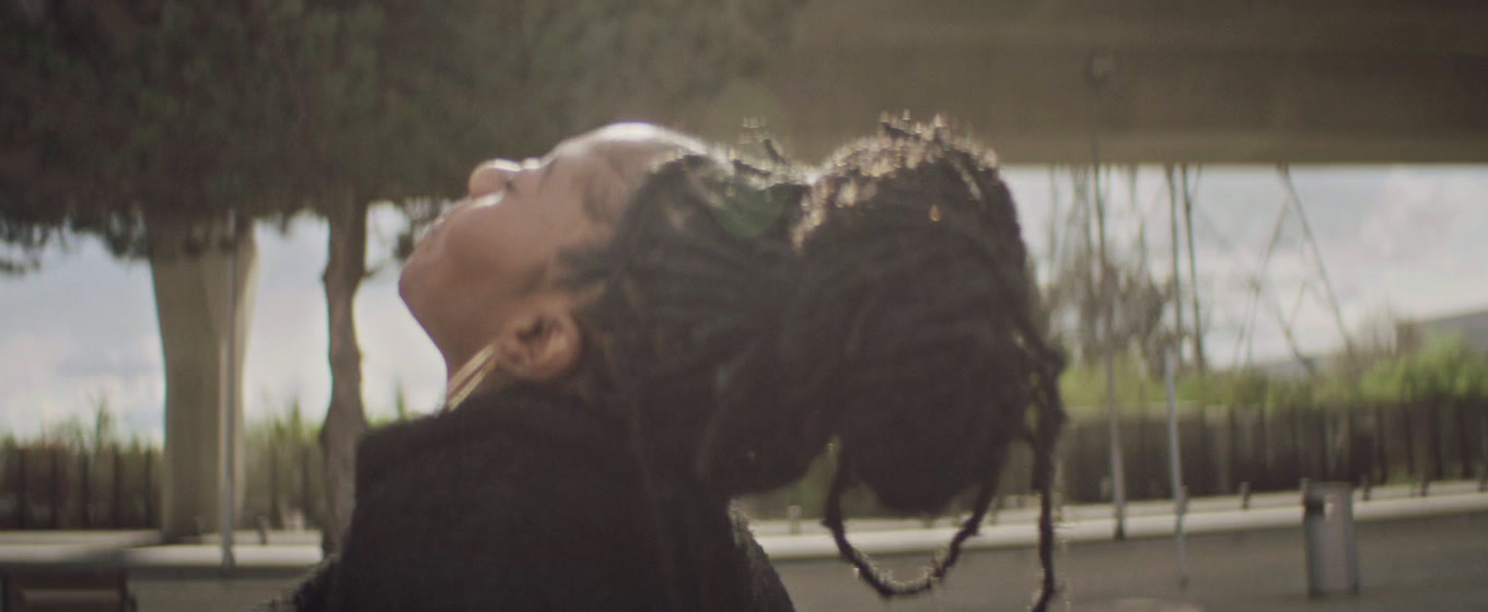 a woman with dreadlocks blowing her hair in the wind