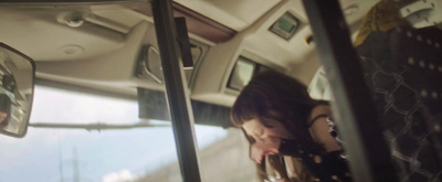 a woman sitting in a bus looking at her cell phone