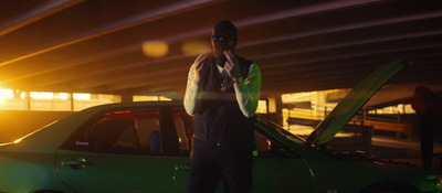 a man standing next to a green car