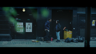 a couple of men standing next to each other on a sidewalk