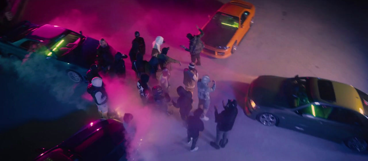 a group of people standing in front of a group of cars