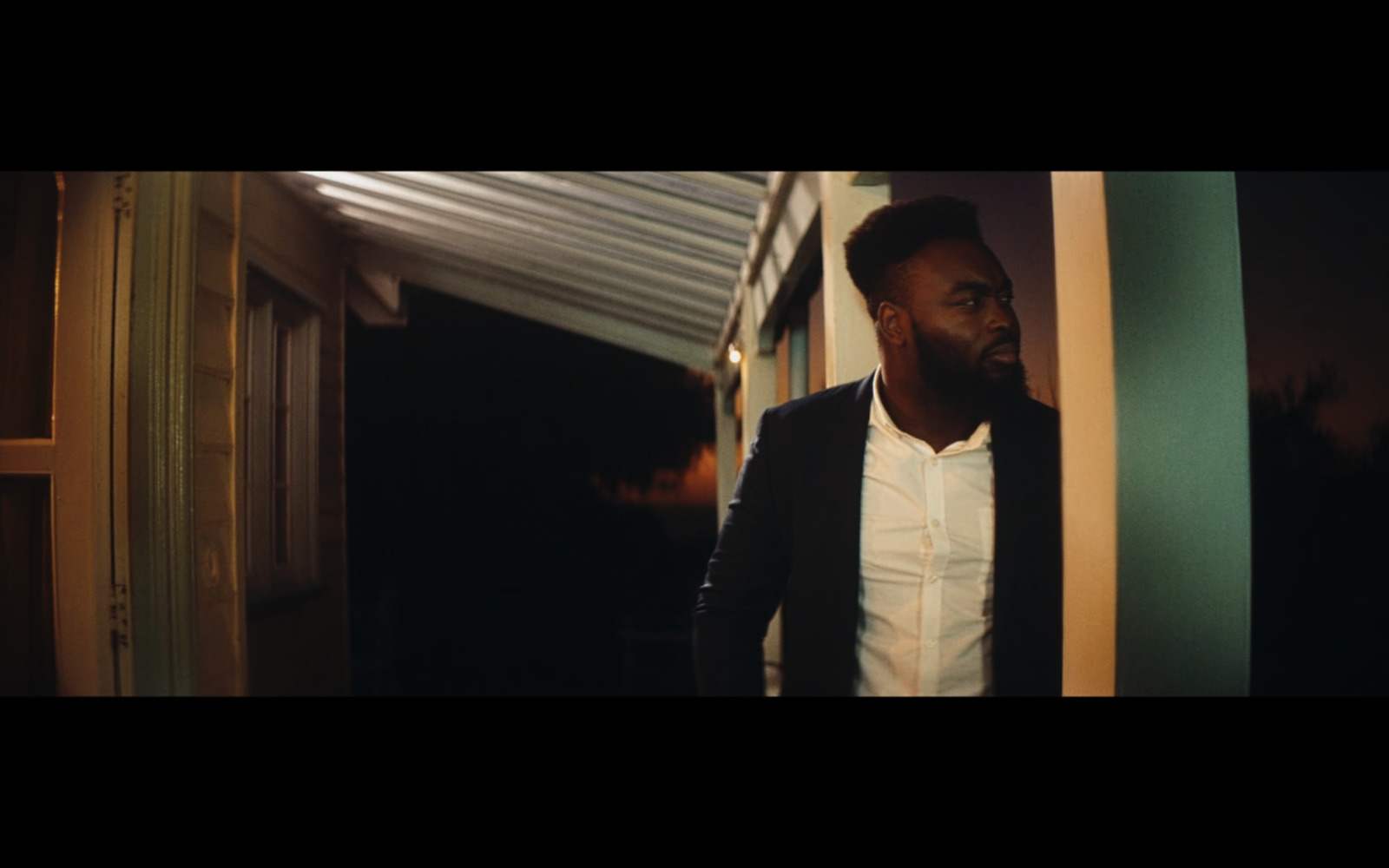 a man with a beard standing in a hallway