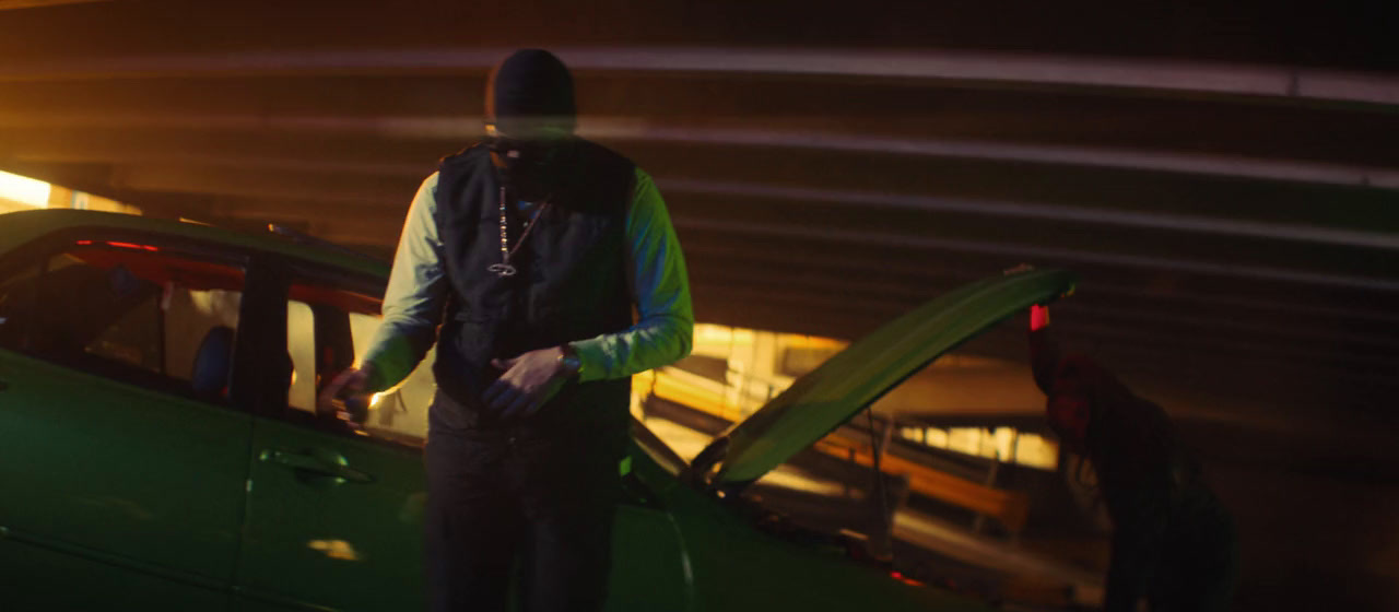 a man standing next to a green car