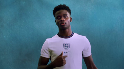 a young man in a white shirt giving a thumbs up