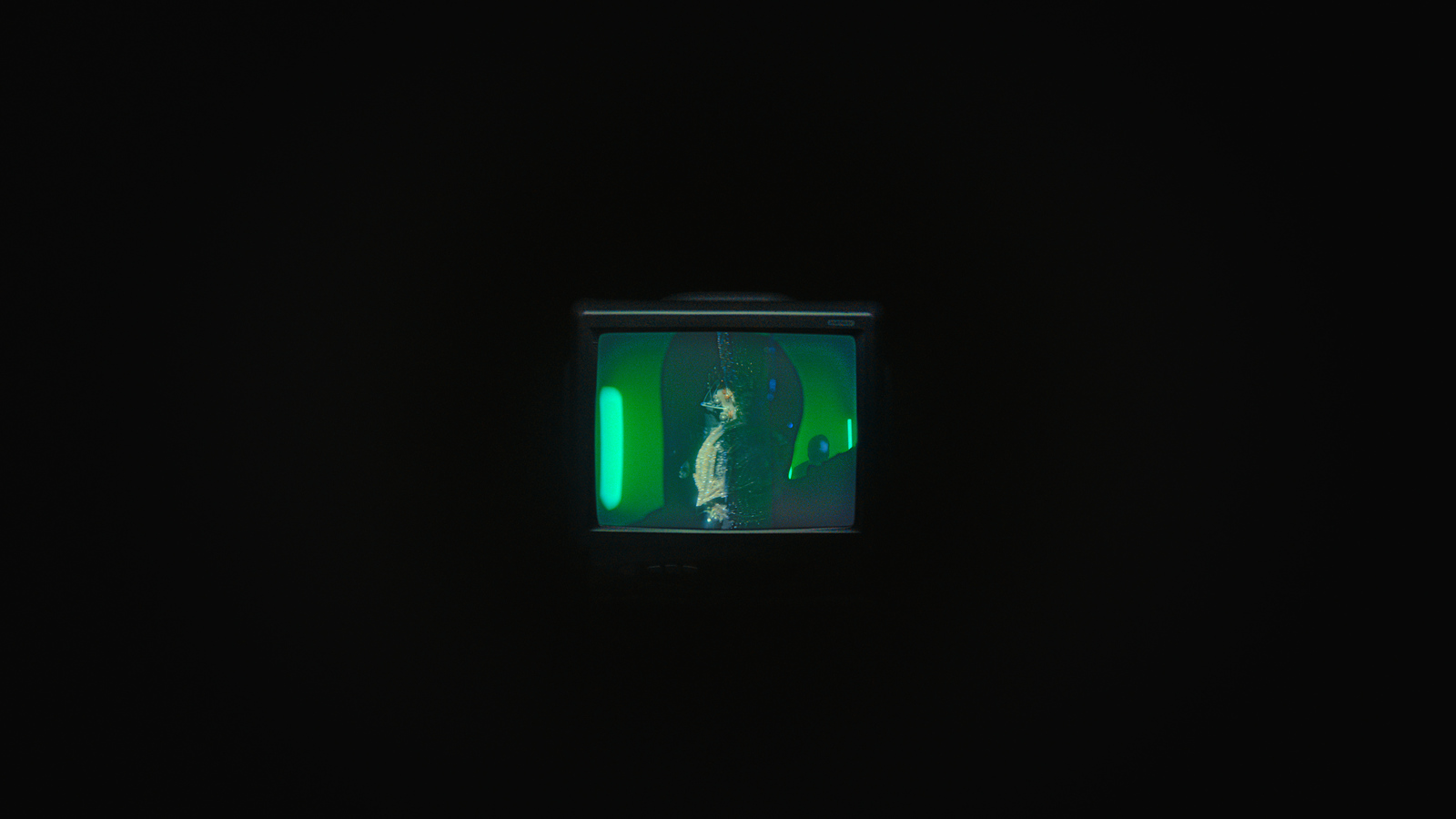 a dark room with a green light in the corner