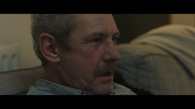 a man with grey hair and a mustache on a couch