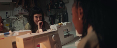 a group of women sitting around a sewing machine