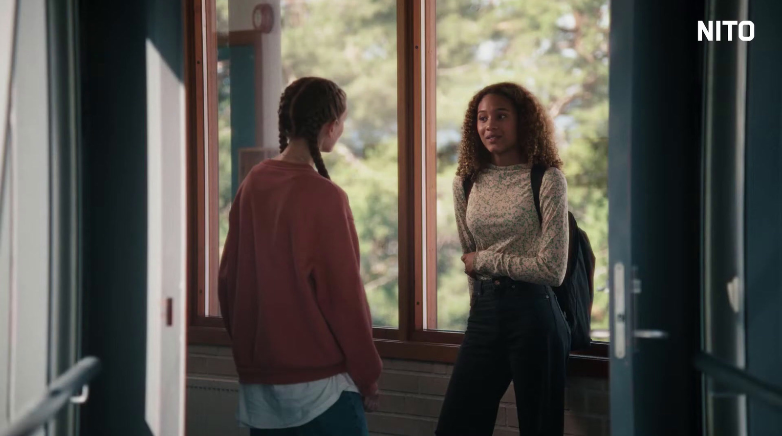 a couple of women standing in front of a window