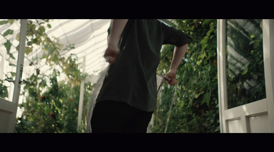 a man standing in front of a greenhouse