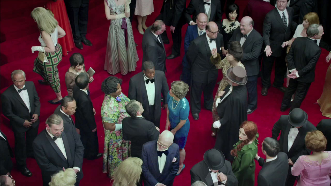 a crowd of people standing on top of a red carpet