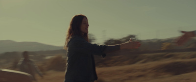 a woman standing in the middle of a field