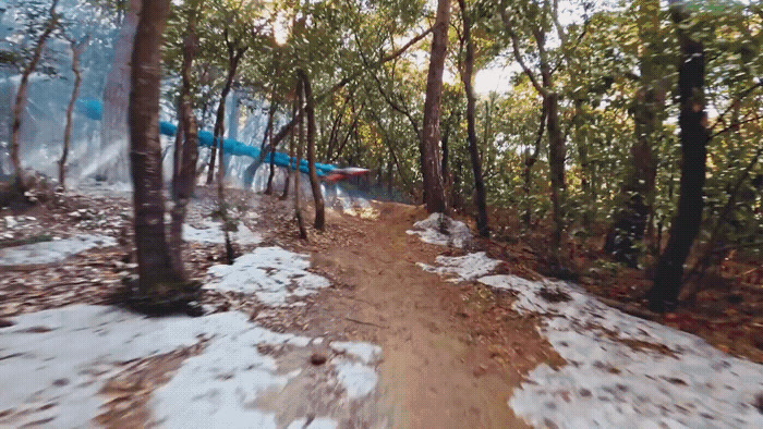 a person riding a snowboard down a snow covered trail